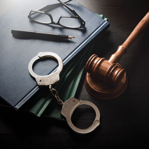 Handcuffs, gavel, legal books: Symbolize criminal defense in Colorado.