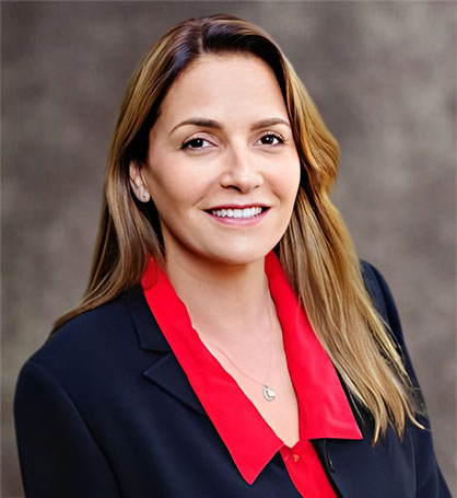 Nancy Kardon, Esq., a smiling woman in a black suit with a red top, standing next to text about Kardon Law and a faint statue of Lady Justice.