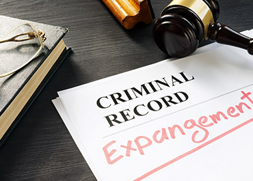 A document labeled CRIMINAL RECORD with Expungement highlighted, next to a gavel and book.