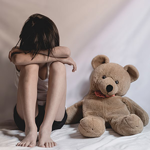 Sad little girl sitting in room. human trafficking concept.